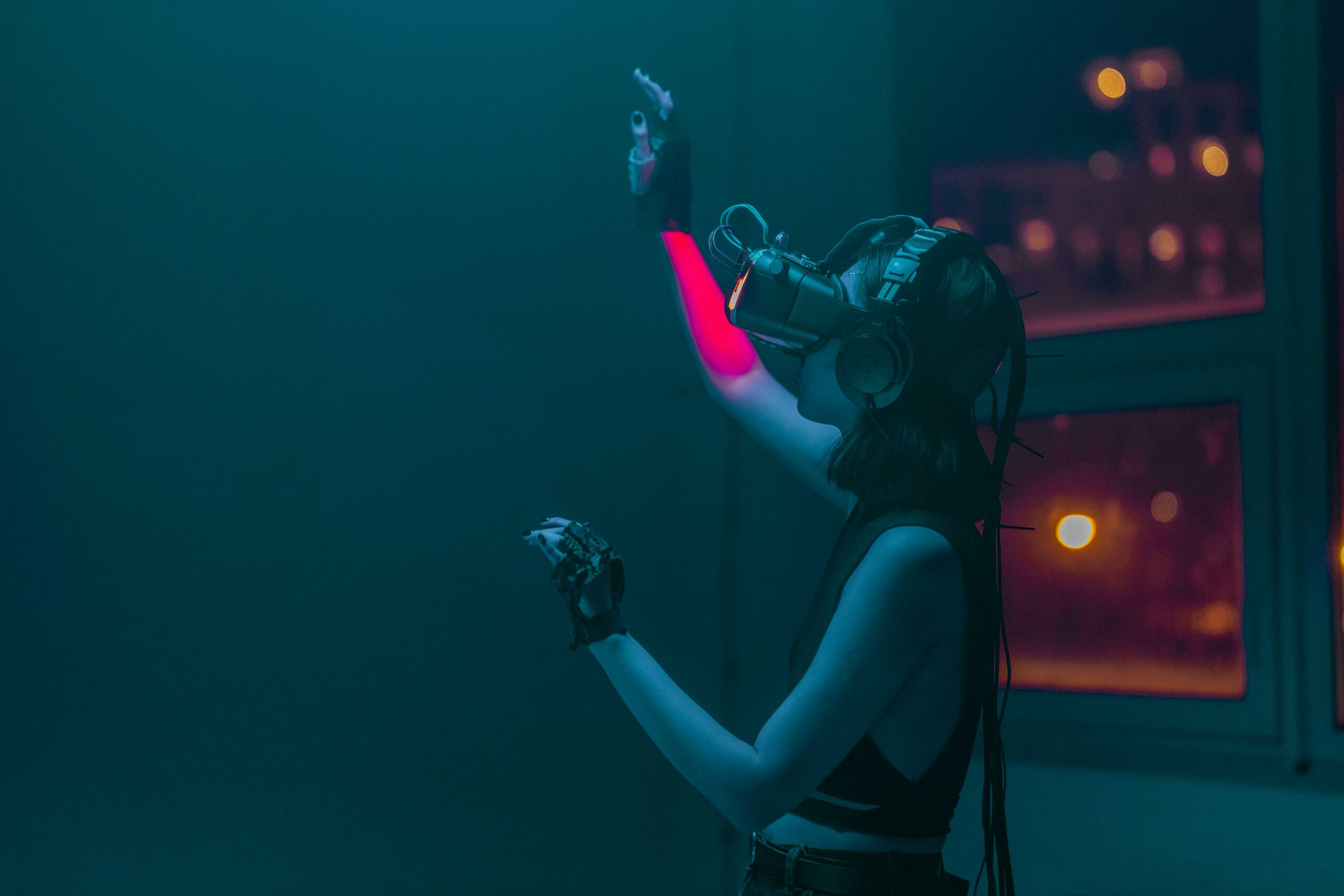 Person with VR headset gesturing in a room with dim, colored lighting